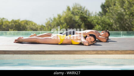 Stupendo giovane giacente sulla piscina vacanze in una giornata di sole Foto Stock