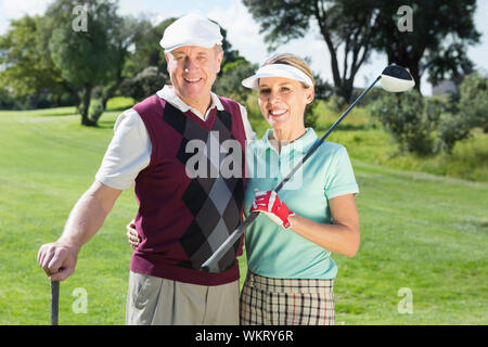 Golf Coppia sorridente alla fotocamera su una soleggiata giornata presso il campo da golf Foto Stock