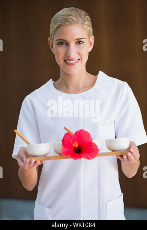 Sorridente terapista di bellezza vaschetta di contenimento dei trattamenti presso il centro termale Foto Stock