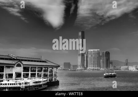 Bianco e nero paesaggio urbano che un traghetto ormeggiato al porto di Victoria in Hong Kong. Foto Stock