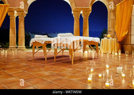 Massaggio tabelle impostato su un patio a lume di candela in un resort. Foto Stock