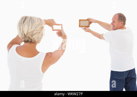 Coppia matura di riagganciare cornice immagine su sfondo bianco Foto Stock
