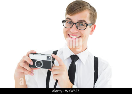 Geeky hipster tenendo una fotocamera retrò su sfondo bianco Foto Stock