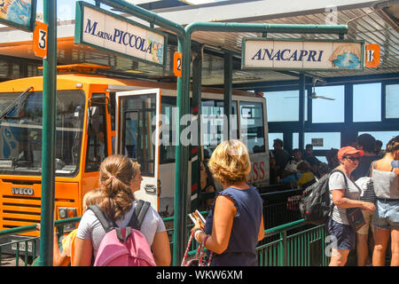 Isola di Capri - Agosto 2019: persone presso la stazione degli autobus nella città di Capri. Piccoli autobus sono utilizzati a causa del molto strette strade sull'isola. Foto Stock