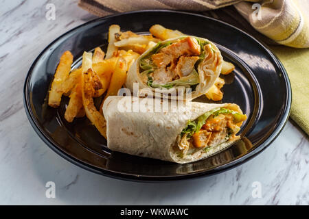 Grigliata di buffalo sandwich di pollo wrap con lattuga romana bleu formaggio e patatine fritte Foto Stock