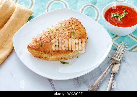 Pasticceria Italiana salsiccia per pizza e formaggio calzone con pomodoro marinara salsa di immersione Foto Stock