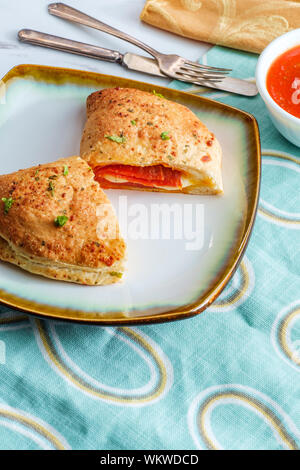 Pasticceria Italiana salsiccia per pizza e formaggio calzone con pomodoro marinara salsa di immersione Foto Stock