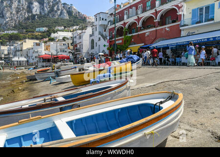 Isola di Capri - Agosto 2019: legno di piccole barche da pesca al di fuori dell'acqua sul lungomare del porto sull'Isola di Capri. Foto Stock