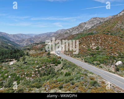 Strada asfaltata si piega attraverso Angeles foreste nazionali di montagna, California, USA. Sottile strada si snoda tra una cresta di colline e montagne in alta quota Foto Stock