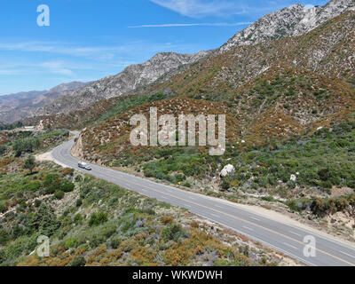 Strada asfaltata si piega attraverso Angeles foreste nazionali di montagna, California, USA. Sottile strada si snoda tra una cresta di colline e montagne in alta quota Foto Stock