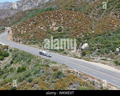 Strada asfaltata si piega attraverso Angeles foreste nazionali di montagna, California, USA. Sottile strada si snoda tra una cresta di colline e montagne in alta quota Foto Stock