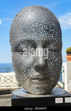 Isola di Capri - Agosto 2019: arte pubblica nella forma di una faccia sul display in Capri. La copertina è realizzata in metallo le catene per bicicletta Foto Stock