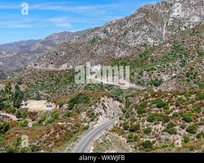 Strada asfaltata si piega attraverso Angeles foreste nazionali di montagna, California, USA. Sottile strada si snoda tra una cresta di colline e montagne in alta quota Foto Stock