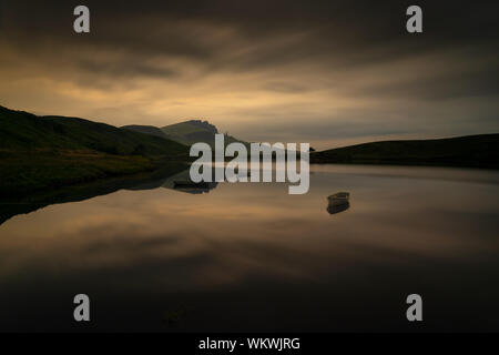 Il vecchio uomo di Storr riflessione in Loch Fada con tre barche, Skye, Scozia Foto Stock