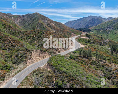 Strada asfaltata si piega attraverso Angeles foreste nazionali di montagna, California, USA. Sottile strada si snoda tra una cresta di colline e montagne in alta quota Foto Stock