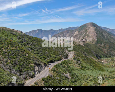 Strada asfaltata si piega attraverso Angeles foreste nazionali di montagna, California, USA. Sottile strada si snoda tra una cresta di colline e montagne in alta quota Foto Stock