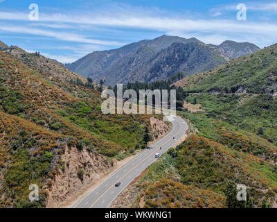 Strada asfaltata si piega attraverso Angeles foreste nazionali di montagna, California, USA. Sottile strada si snoda tra una cresta di colline e montagne in alta quota Foto Stock