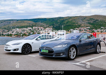 Due Tesla auto elettrica ricarica accanto al mare Adriatico nella città di Senj in Croazia Foto Stock