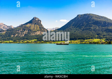 La splendida vista dal Sanktwolfgang im Salzkammergut sulle montagne delle Alpi, nave steamboat, Sparber montagna, Sparber montagna, lago Wolfgangsee, cielo blu. Foto Stock
