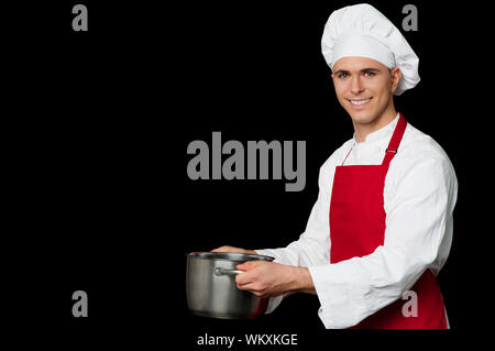 Il giovane chef holding pentola vuota in mani Foto Stock