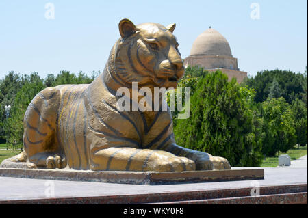 Custode di Golden Lion statue presso l'entrata di Amir Timur Park, Samarcanda, Uzbekistan Foto Stock