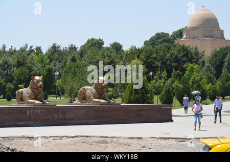 Custode di Golden Lion statue presso l'entrata di Amir Timur Park, Samarcanda, Uzbekistan Foto Stock