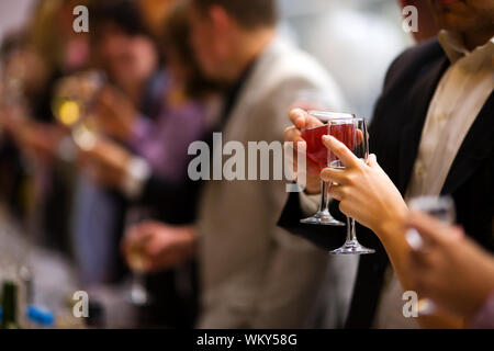 Evento di festa la gente acclamava ogni altra con champagne e vino Foto Stock