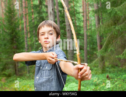 Ragazzo puntando a casa di legno fatti a prua all'aperto Foto Stock