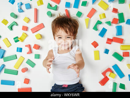 Carino divertente bambina ritratto sul giocattolo colorati mattoni in legno sfondo Foto Stock