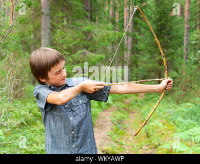 Ragazzo puntando a casa di legno fatti a prua all'aperto Foto Stock