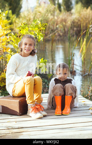 Bambini che giocavano nei pressi del lago in autunno Foto Stock