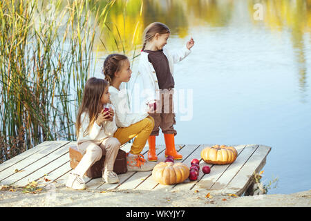 Bambini che giocavano nei pressi del lago in autunno Foto Stock