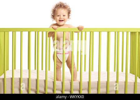 Sorridente carino il bambino in piedi nella culla isolati su sfondo bianco Foto Stock
