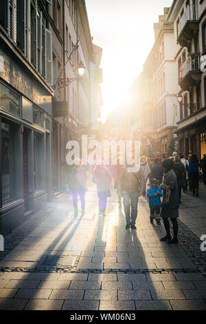 Strasburgo, Francia - 28 OTT 2017: i pedoni a camminare sulla strada dello shopping con svasatura del tramonto sullo sfondo Foto Stock