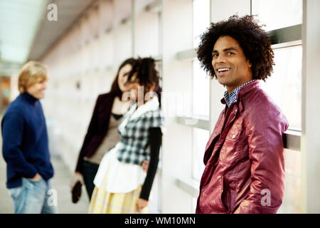 Un giovane americano africano uomo con un gruppo di persone in background Foto Stock