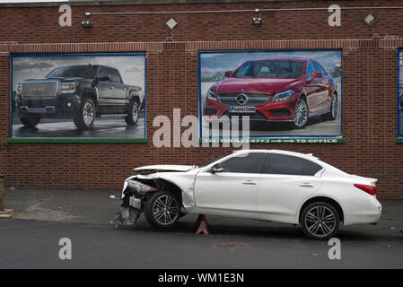 Auto su jack-sorge al di fuori di un negozio di riparazioni auto nel Queens, a New York Foto Stock