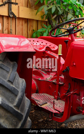 Trattore rosso parcheggiato in un granaio Foto Stock