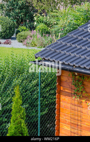 Casa giardino sul tetto, pulire la grondaia in estate Foto Stock