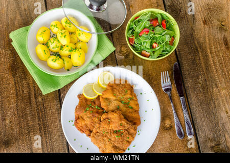 Il tedesco Schnitzel con patate e cipolla e limone Foto Stock