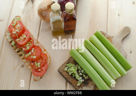 Baguette alla griglia con pomodori grigliati, olio di oliva e di sedano tagliato Foto Stock