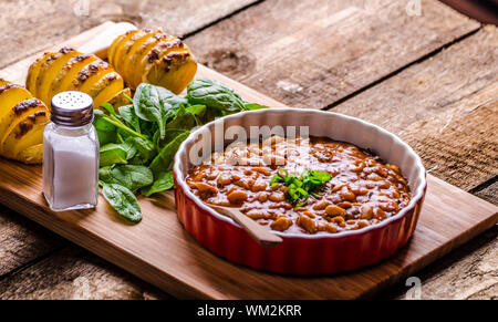 Cowboy piccante fagioli con peperoncino jalapeno, lo scalogno e la pancetta, Hassleback Potatoe con erbe aromatiche Foto Stock