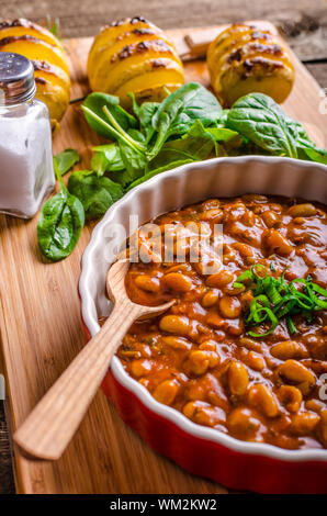 Cowboy piccante fagioli con peperoncino jalapeno, lo scalogno e la pancetta, Hassleback Potatoe con erbe aromatiche Foto Stock