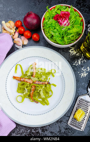Italian pasta agli spinaci con organici aglio e pancetta e formaggio parmigiano Foto Stock