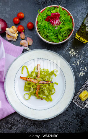 Italian pasta agli spinaci con organici aglio e pancetta e formaggio parmigiano Foto Stock