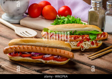 Variazione su red hot dogs, cipolla pomodoro, rucola e peperoncino piccante con spaghetti cinesi Foto Stock