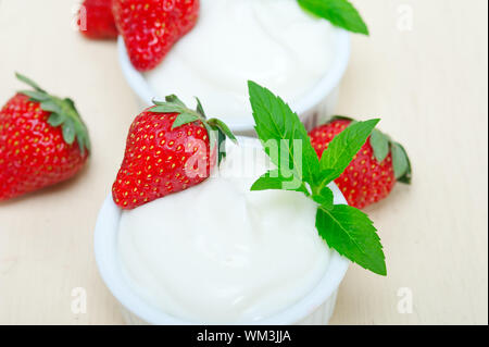 Organici di yogurt greco e fragole bianco su tavola in legno rustico Foto Stock