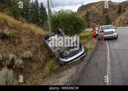 Okanagan Falls, Penticton, British Columbia, Canada - 11 agosto 2019: veicolo incidente ribaltato sul lato della strada durante un giorno di pioggia. Foto Stock
