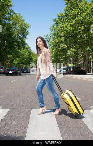 Donna tirando la valigia in Street nella città di Madrid Spagna Foto Stock