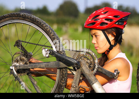 La riparazione di biciclette. Donna riparazione di mountain bike. Foto Stock