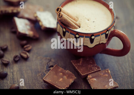 Caffè in grani tostati con bastoncini di cannella in tazza di ceramica  bianca sfondo blu Foto stock - Alamy